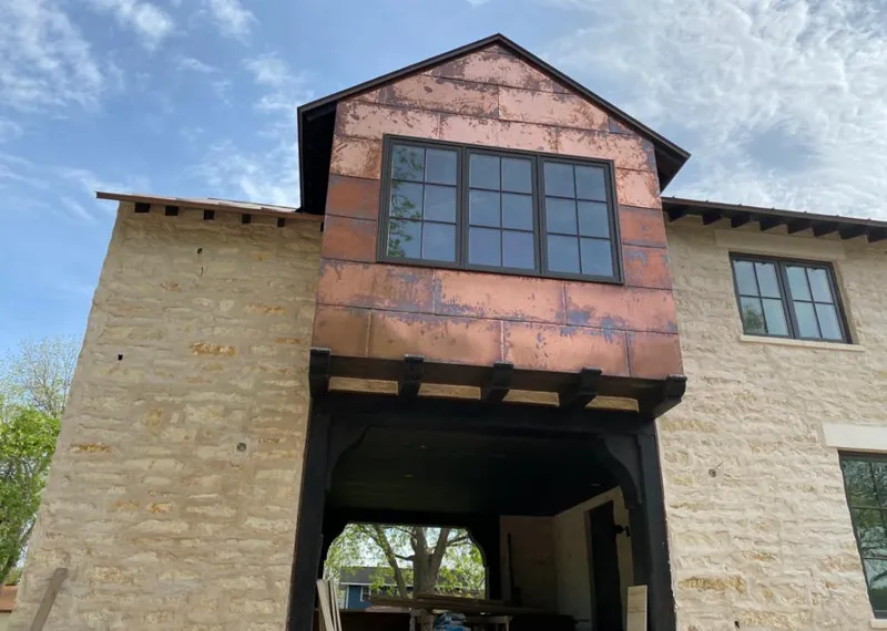 Copper metal panel facade on a stone building for Metal Roof Coating in Bryan